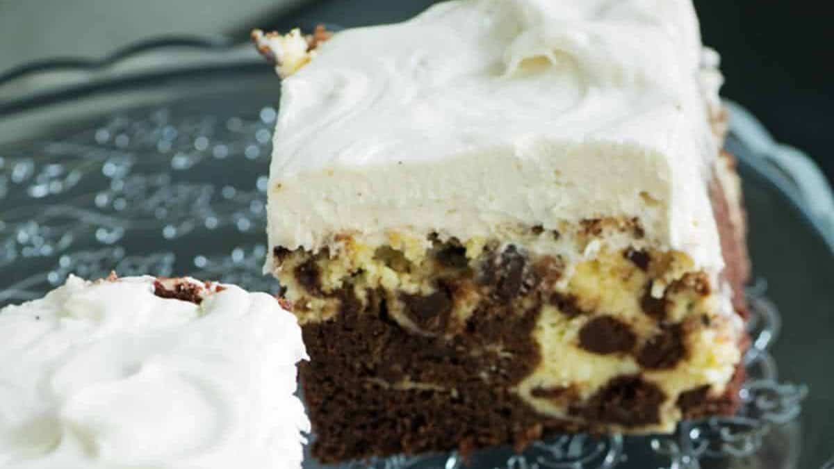 Two squares of chocolate cake with cream cheese frosting.