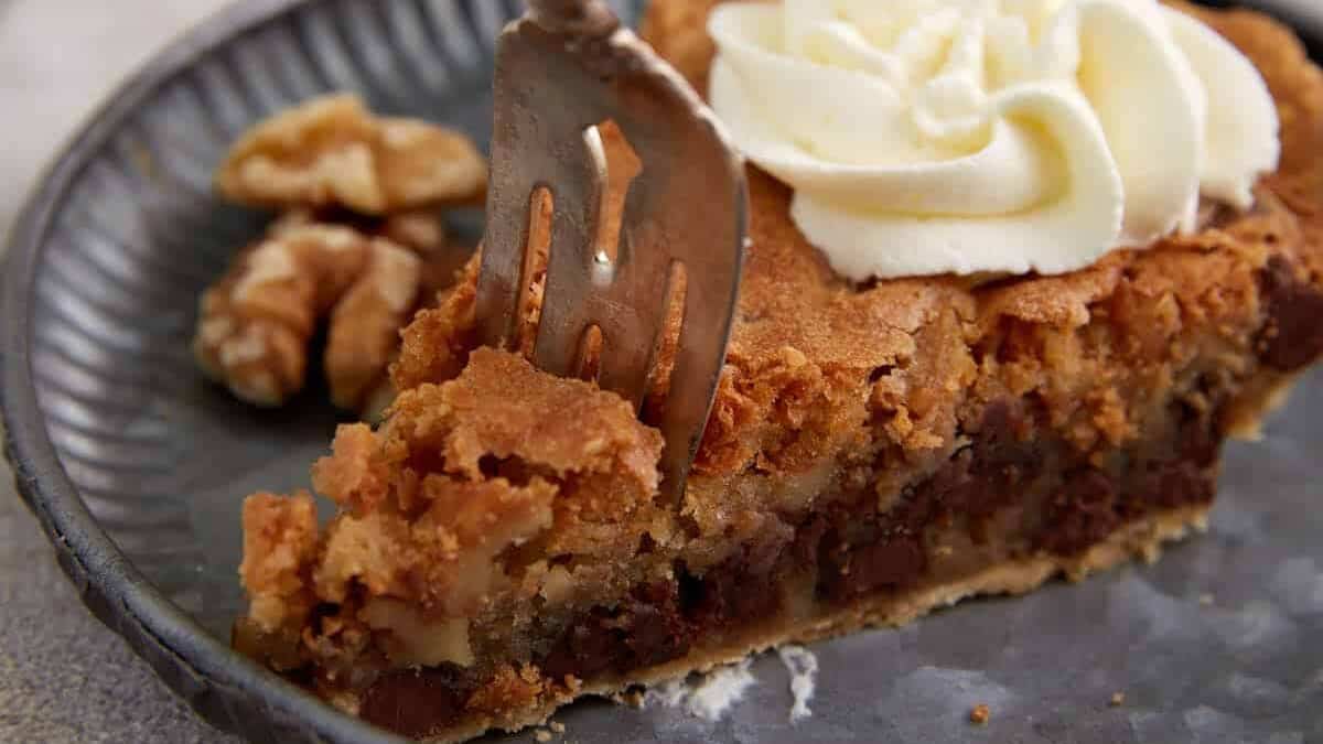 A fork cutting a bite of derby pie.