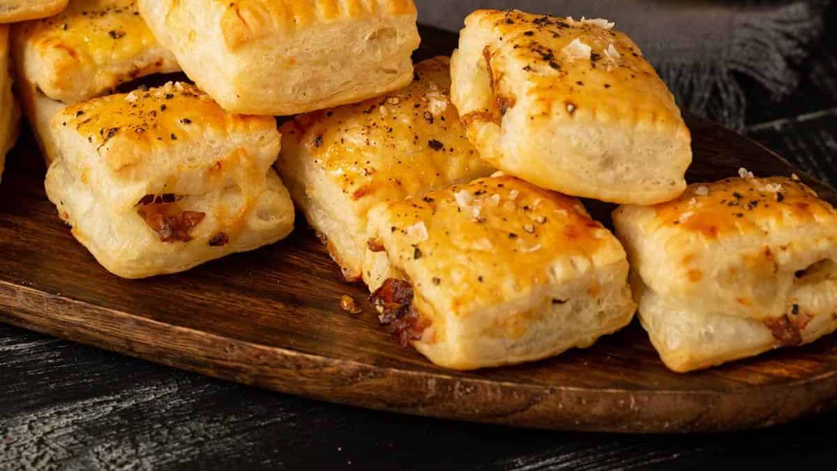 French onion pastry bites on a platter with a glass of wine.