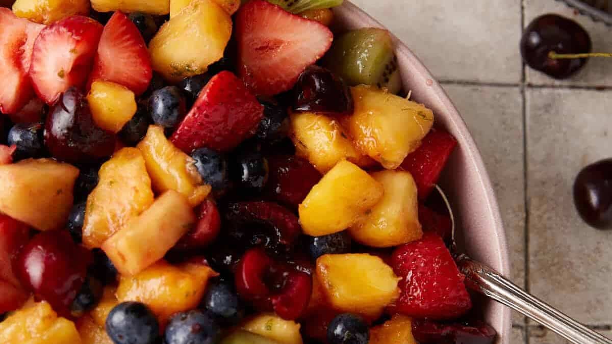 Mixed fruit salad with lime dressing in a bowl.