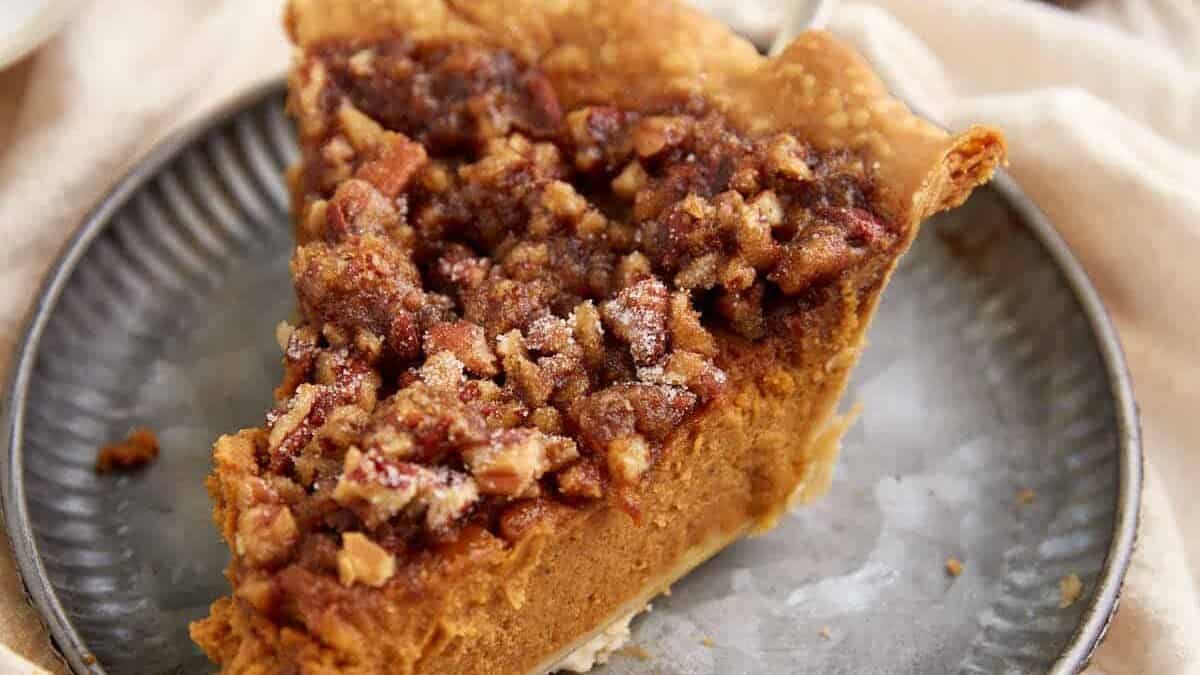 A slice of pumpkin pie topped with pralines.