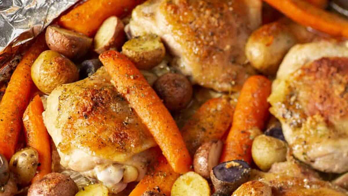 Ranch chicken on a sheet pan with carrots and potaotes.