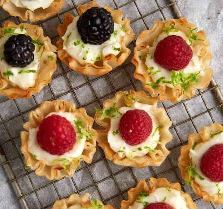 A tray of raspberry tarts in phyllo cups.