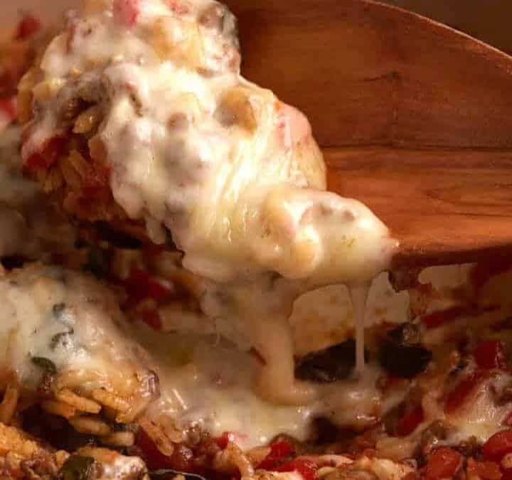 Skillet Hamburger and Rice casserole with a wooden spoon.