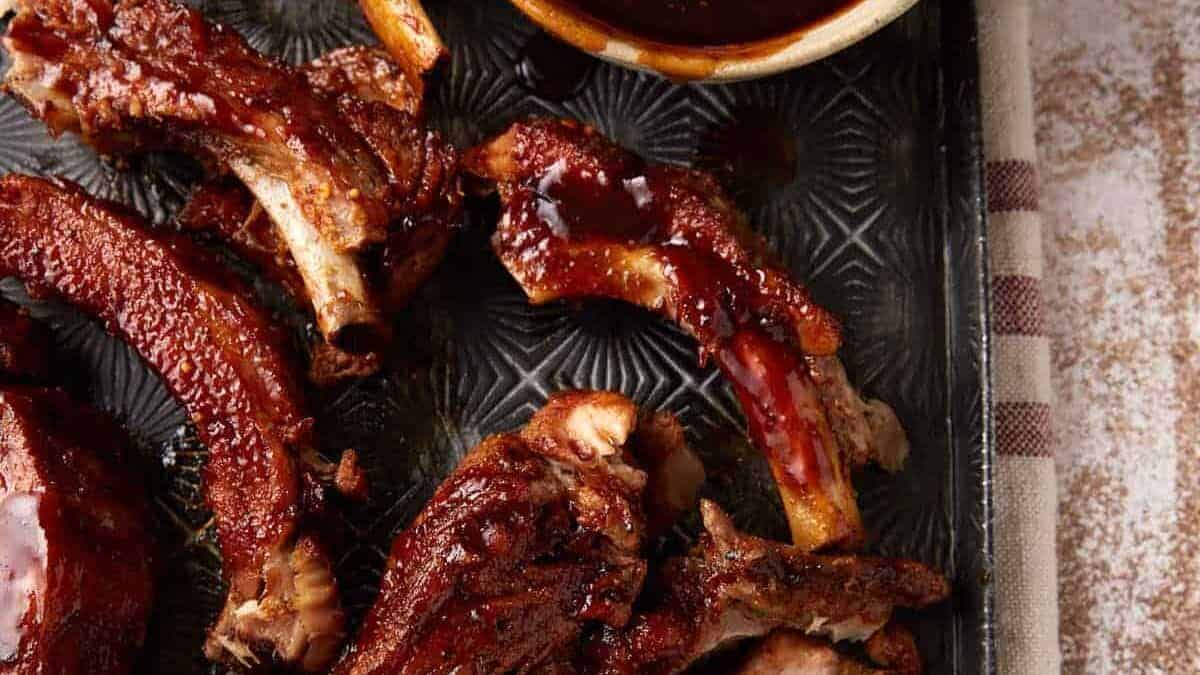 A tray of slow cooker ribs with bbq sauce.