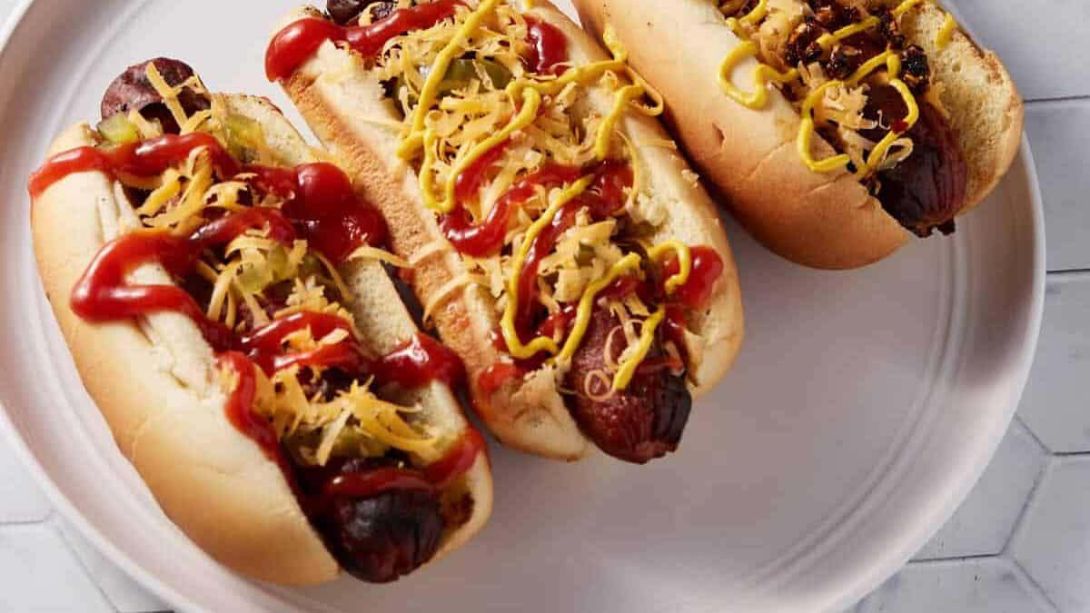 Three spiral hot dogs on a white platter.