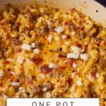 A close-up of a skillet containing creamy, cheesy macaroni mixed with ground beef, melted cheddar, and sprinkled with chopped onions. The text overlay reads, "One Pot Cheeseburger Mac." The website name "butterandbaggage.com" is visible at the top of the image. This is your ultimate cheeseburger macaroni delight!