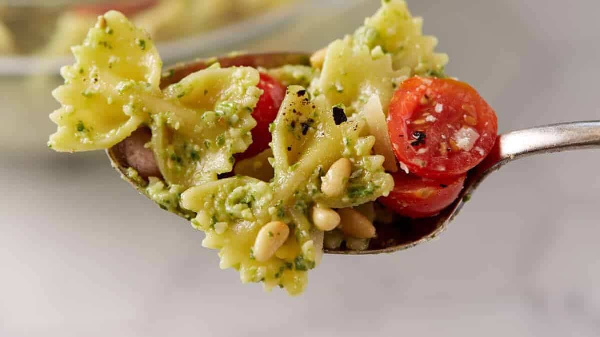 Mouthwatering pesto pasta salad recipe with vibrant colors on a spoon.