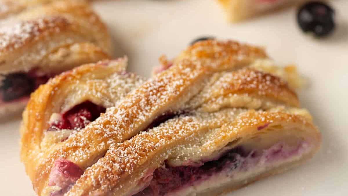 Slices of pastry with berries in the background.