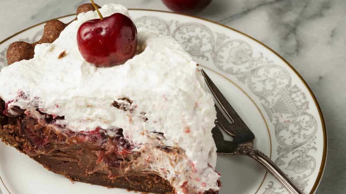 Cherries next to a slice of chocolate pie.