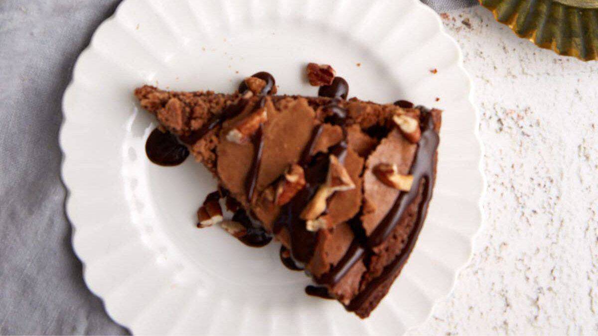 A slice of brownie pie with chocolate syrup.