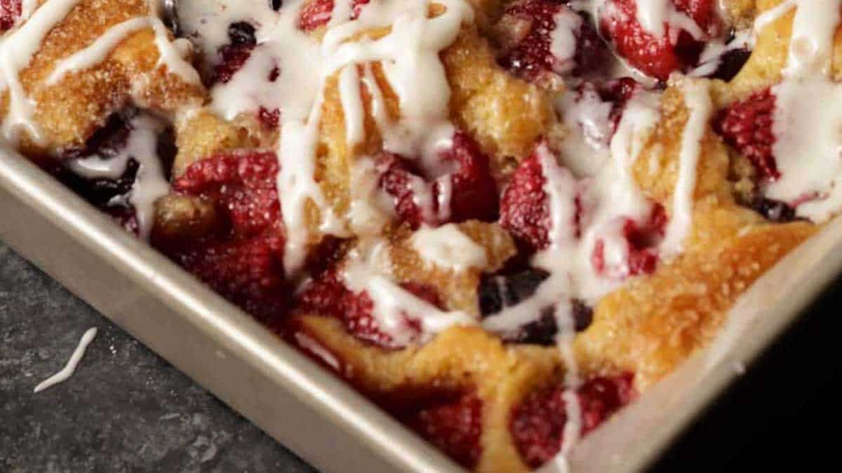 A baking pan of fruit filled coffee cake with icing.