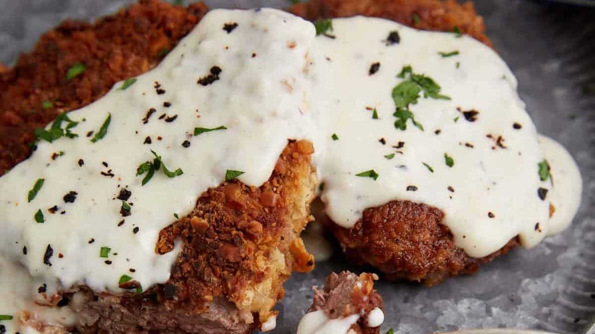A bite of chicken fried steak on a fork.