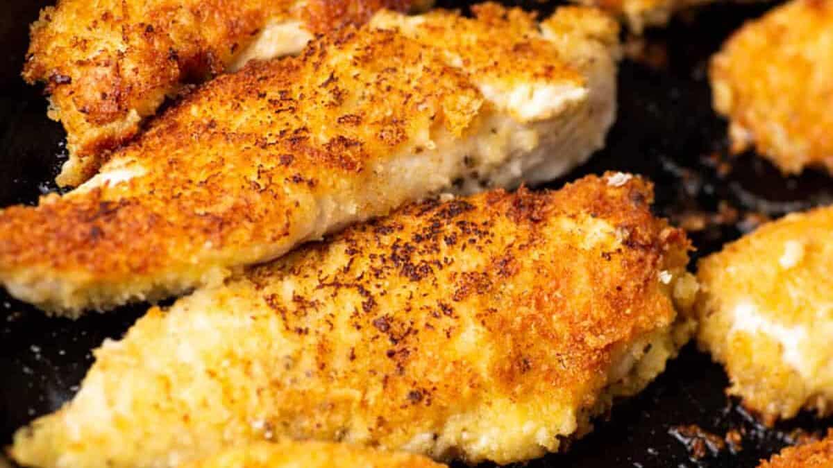 An iron skillet filled with chicken tenders.