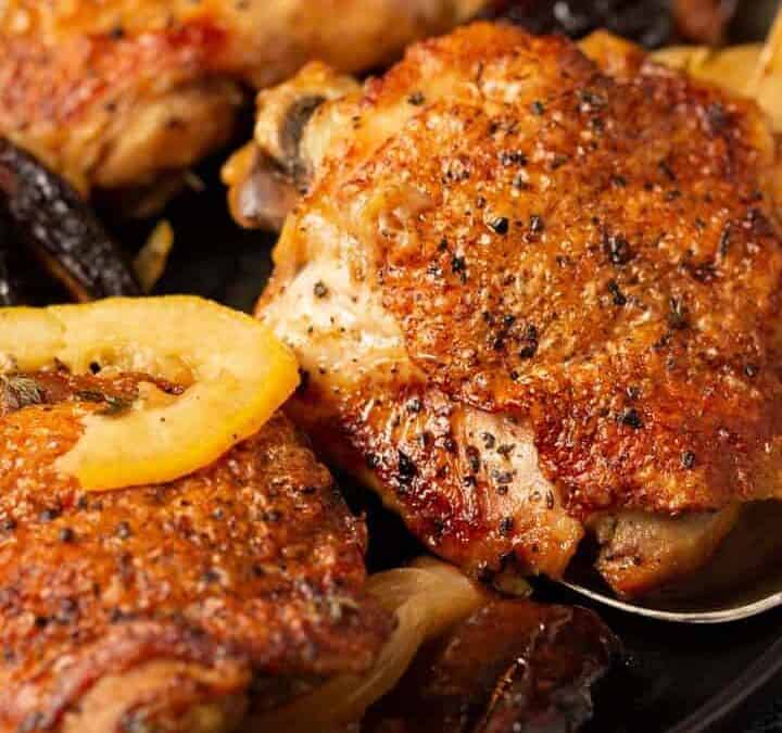 A baked chicken breast being removed from a serving platter.