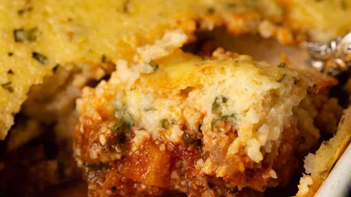 A spoonful of chili casserole topped with baked grits.