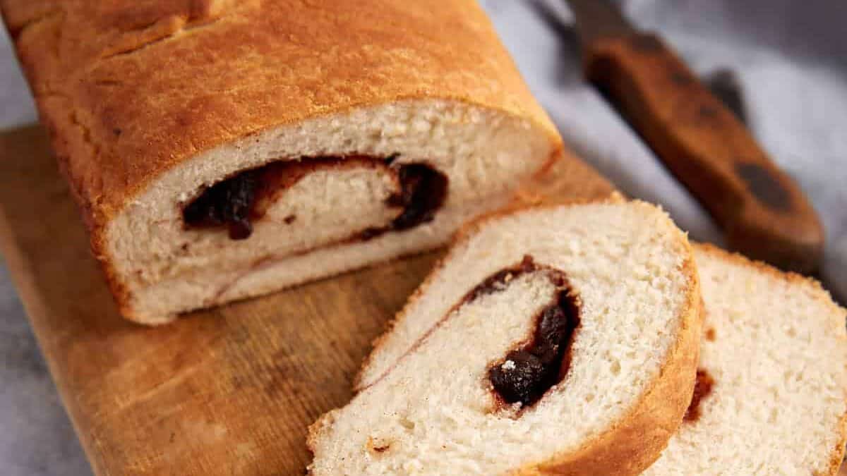 A loaf of cinnamon raisins bread with cut slices.