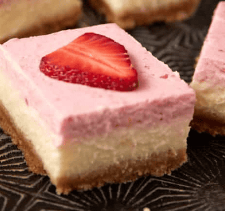 strawberry cheesecake bars on a baking tray.