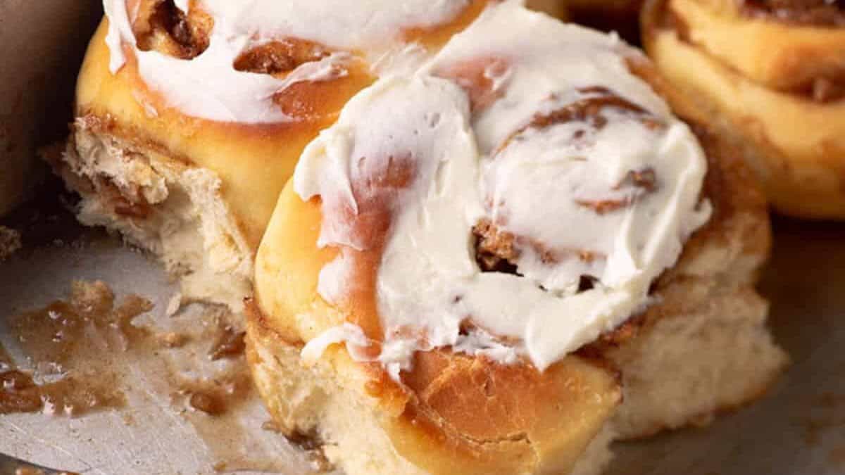 Soft cinnamon rolls with frosting in a baking pan.