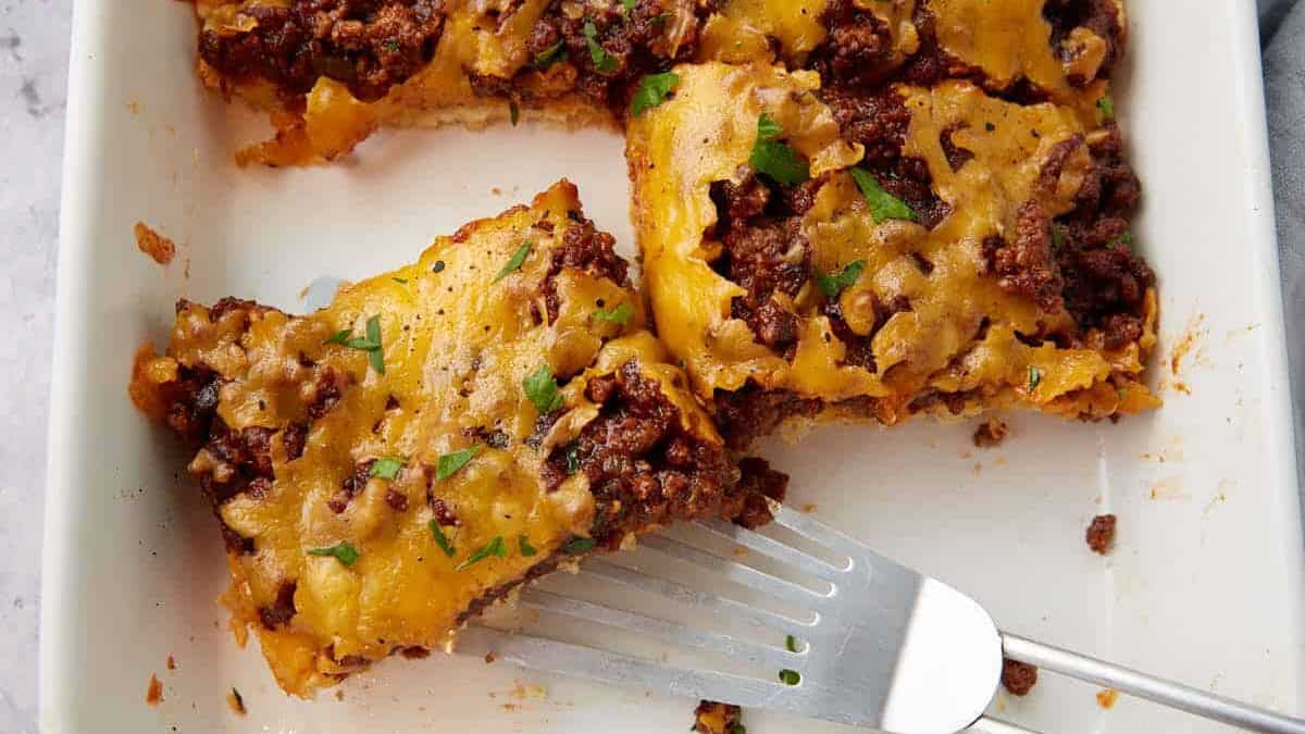 A spatula removing a serving of hamburger casserole.