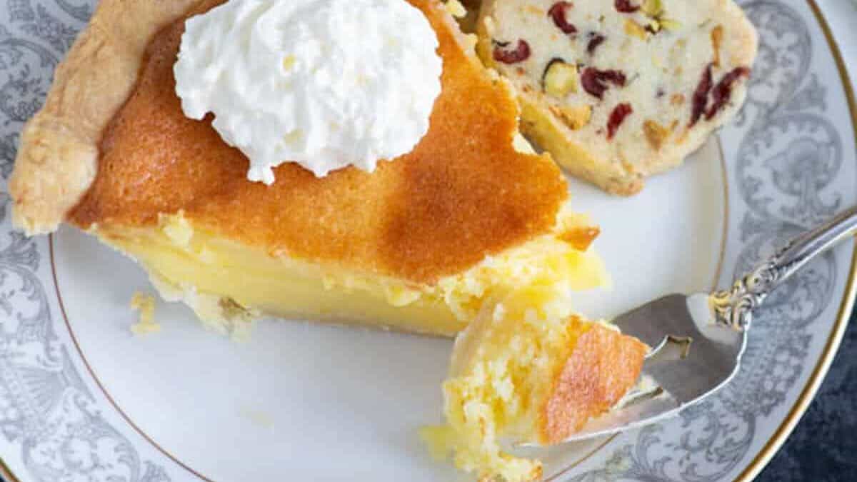 A bite of chess pie on a fork next to a slice of pie.