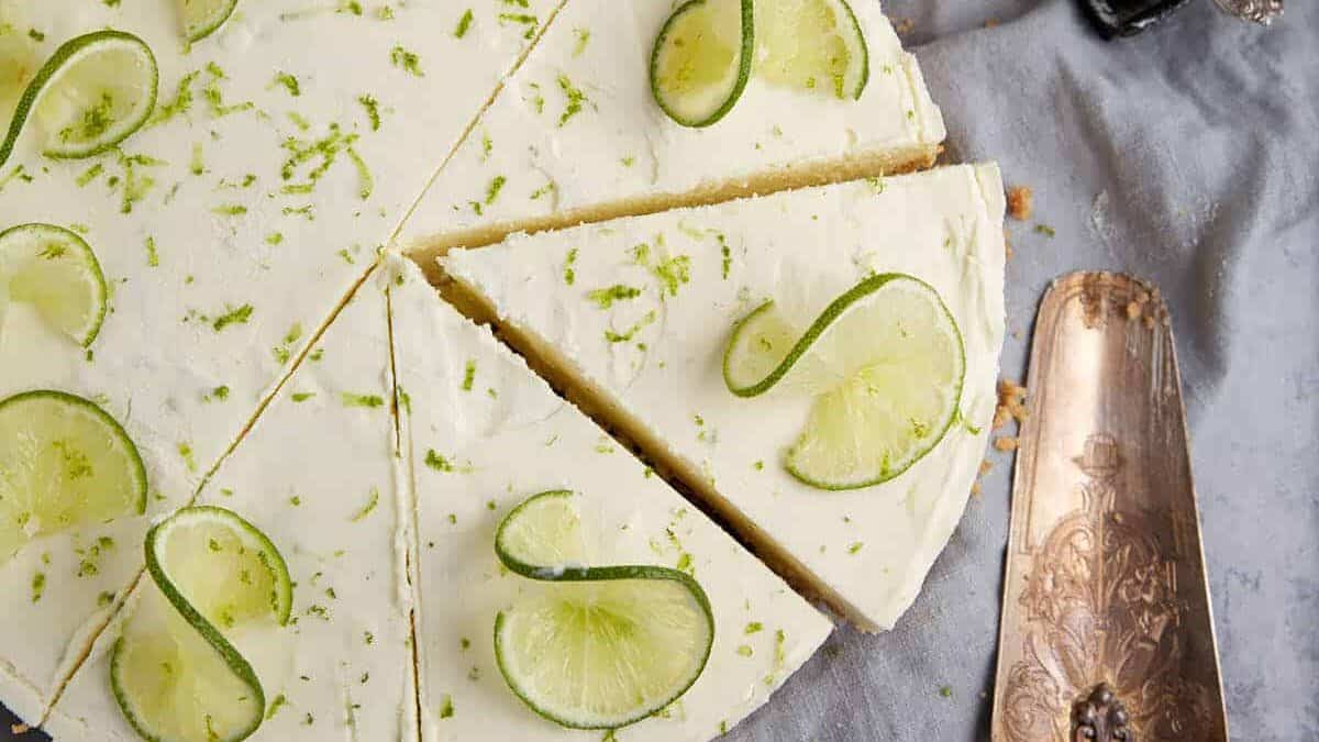 A sliced key lime pie next to a pie server.