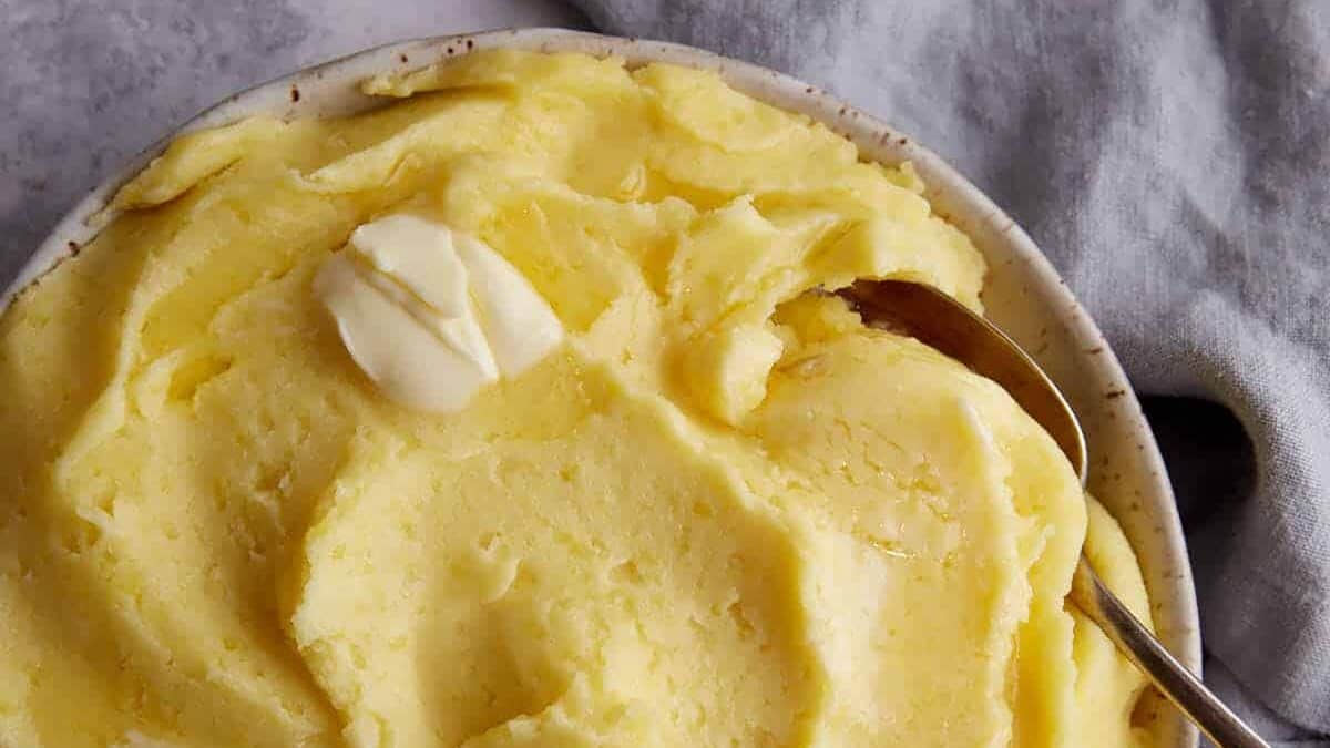 Butter on top of a bowl of mashed potatoes.