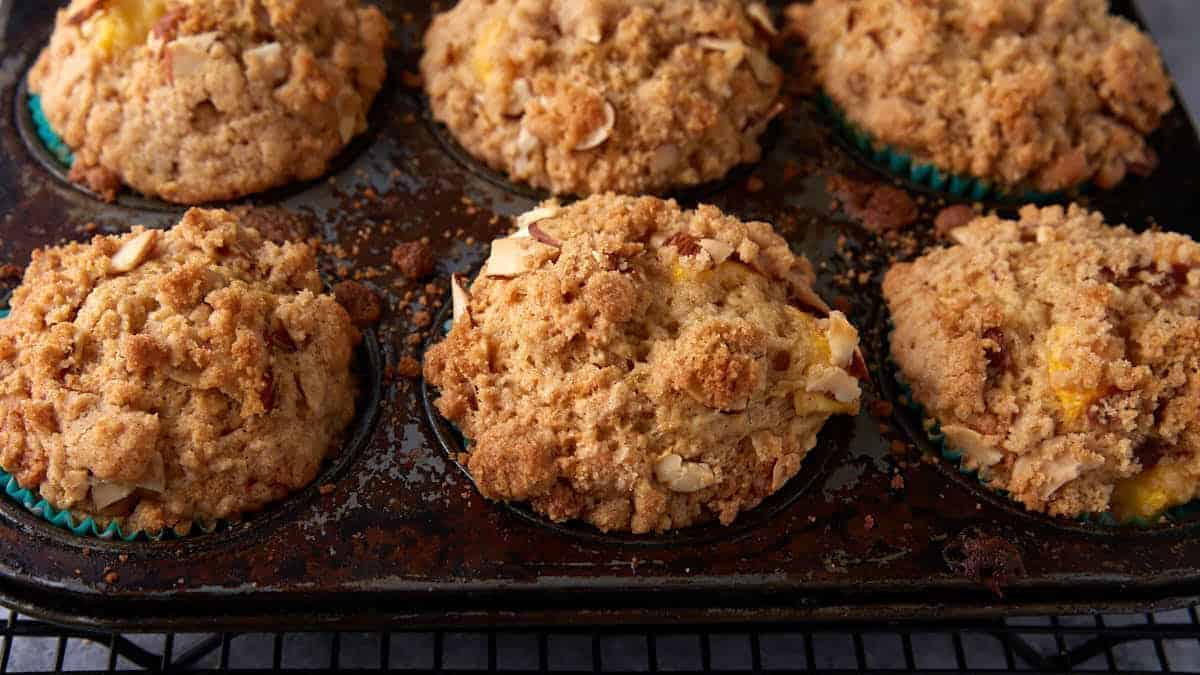 Peach muffins cooling on a wire rack.