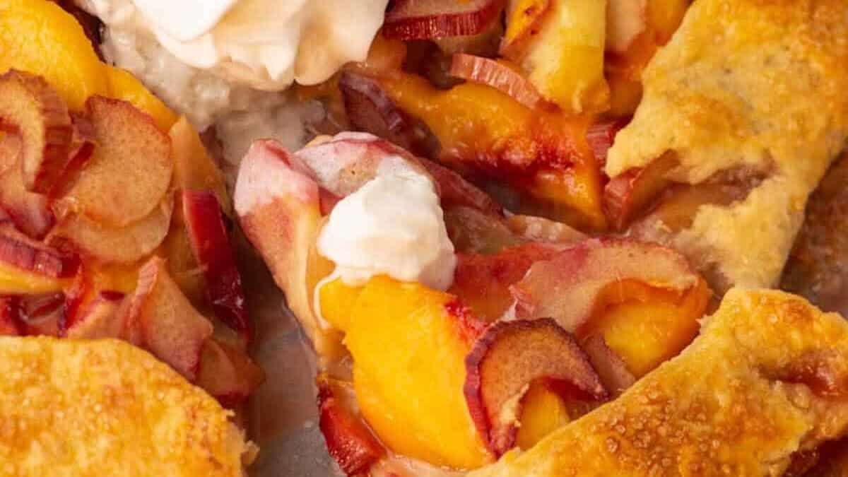 A galette with peaches and rhubarb with whipped cream.