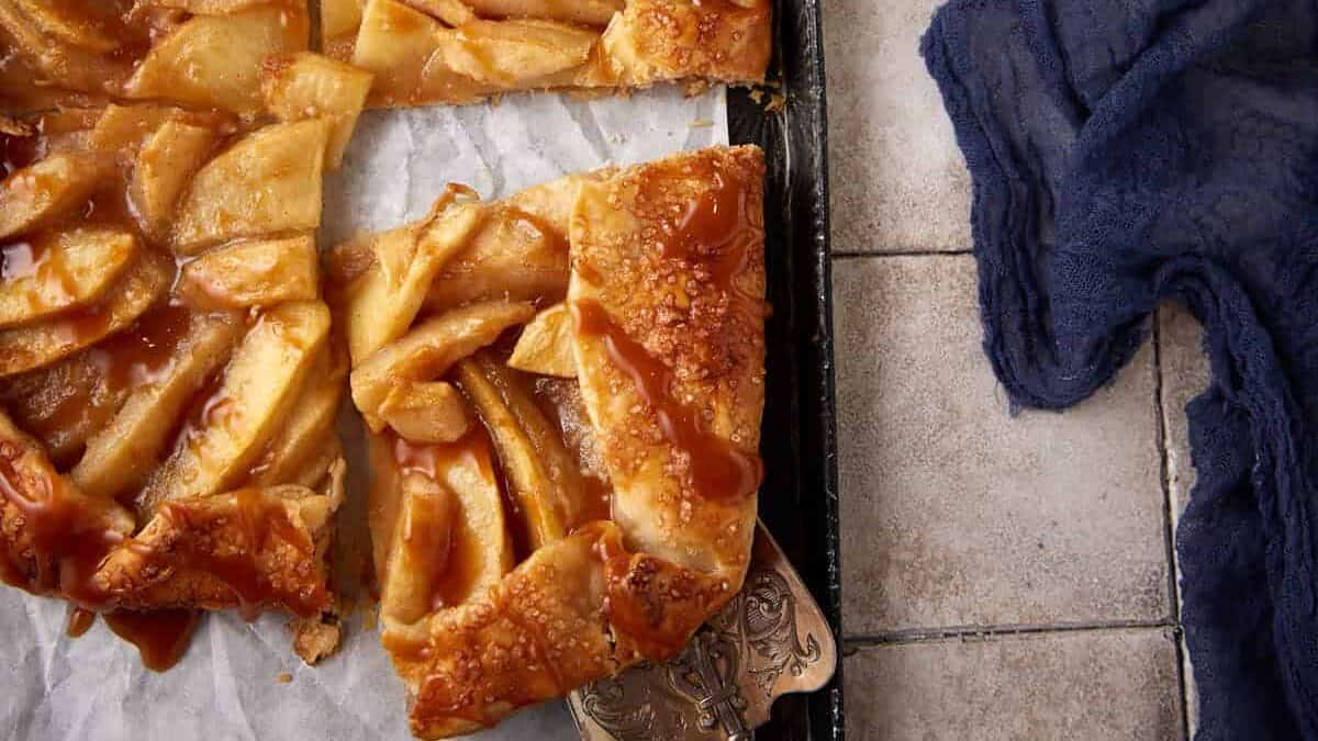 A slice removed from a pear and apple galette.