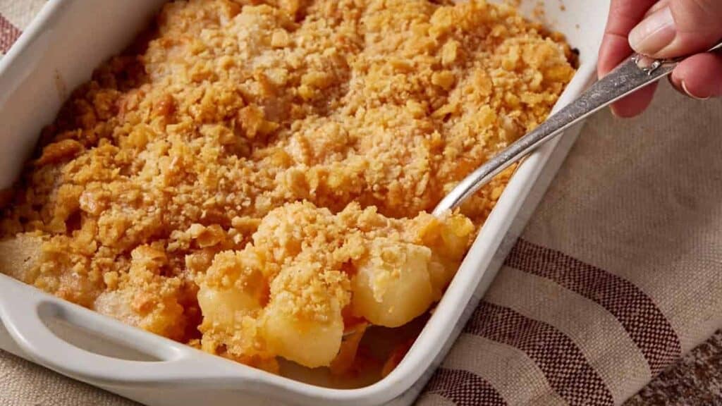 A spoon full of pineapple cheese casserole.