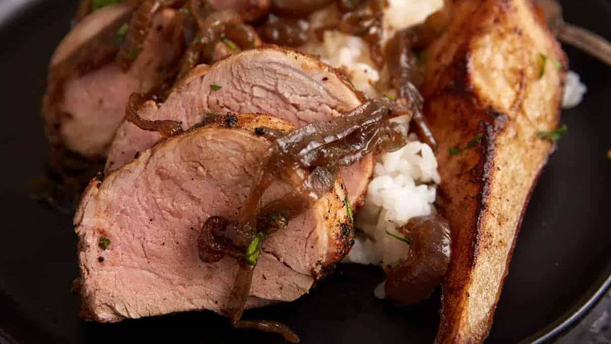 A serving of pork tenderloin over rice.