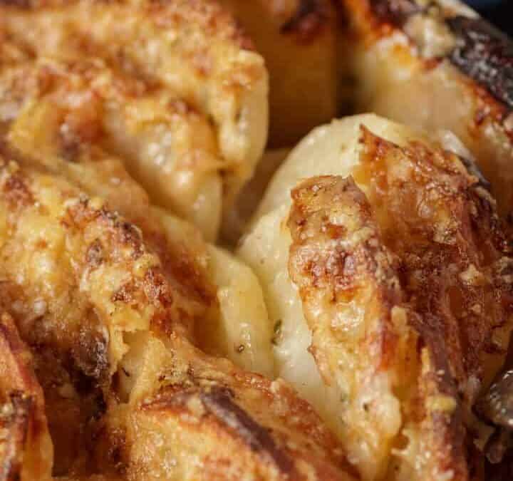 Potatoes au gratin in a baking dish with a serving spoon.