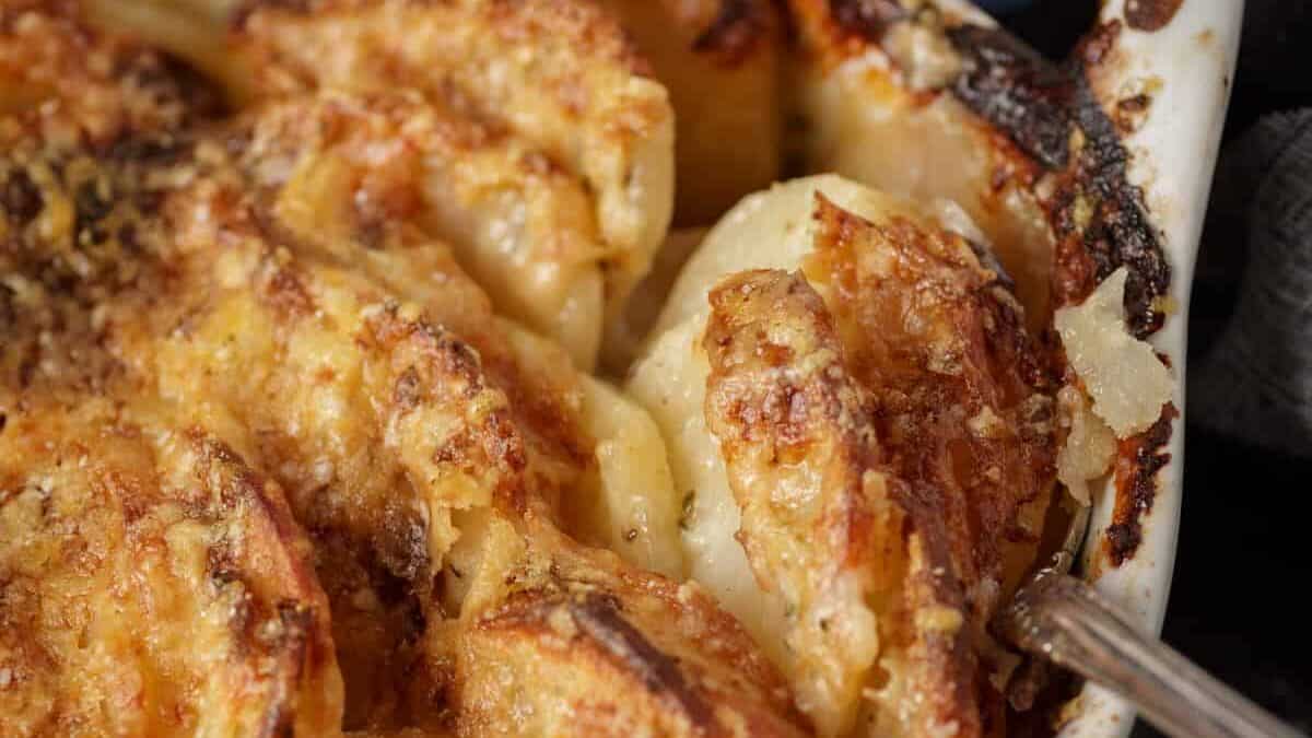 Potatoes au gratin in a baking dish with a serving spoon.