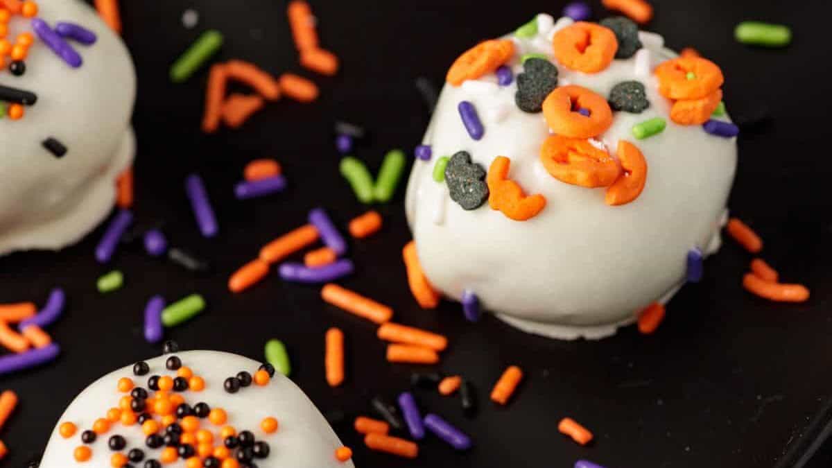 Pumpkin cheesecake balls topped with Halloween sprinkles.