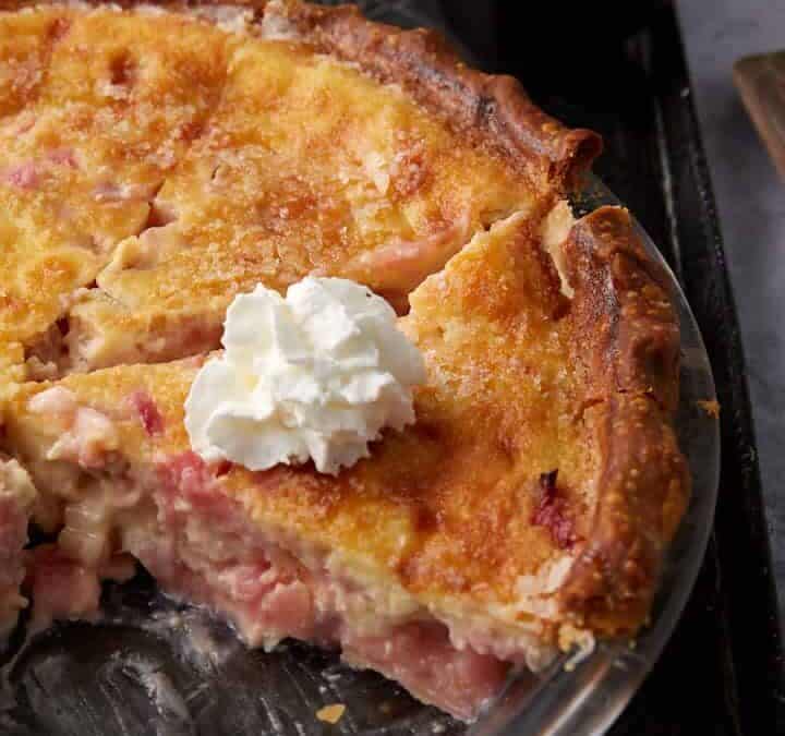 A slice of rhubarb pie with whipped cream on top.