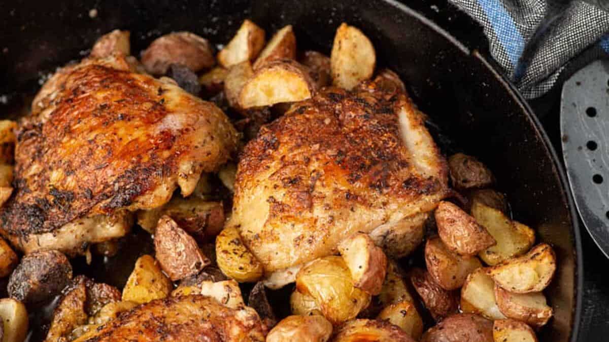 Roasted chicken with potatoes and mustard in a skillet.
