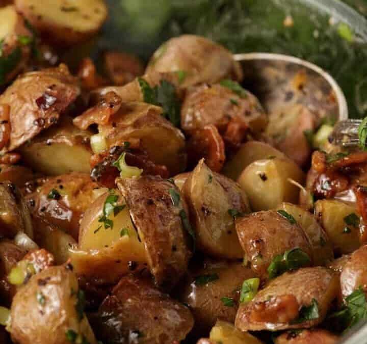 A glass bowl of roasted potato salad