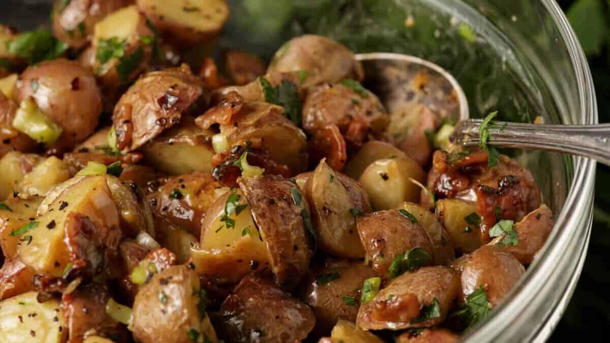 A glass bowl of roasted potato salad