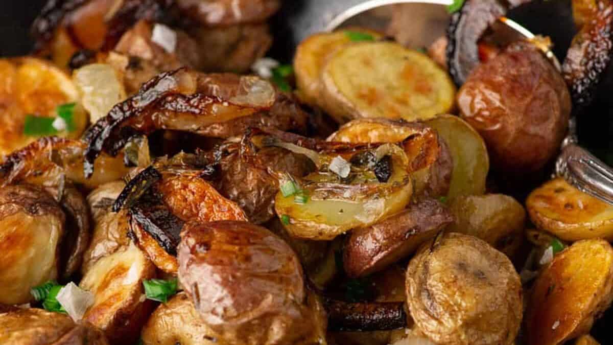 A serving spoon in a bowl of crispy potatoes and onions.