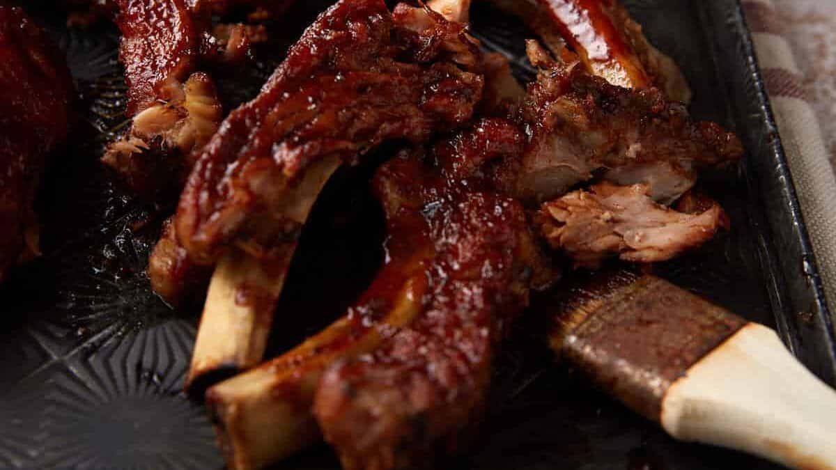 Barbecue ribs with a bowl of sacue.