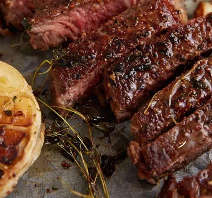 A pan seared steak sliced on a serving platter.