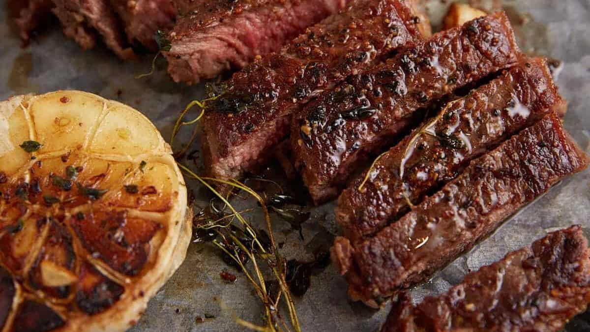 A pan seared steak sliced on a serving platter.