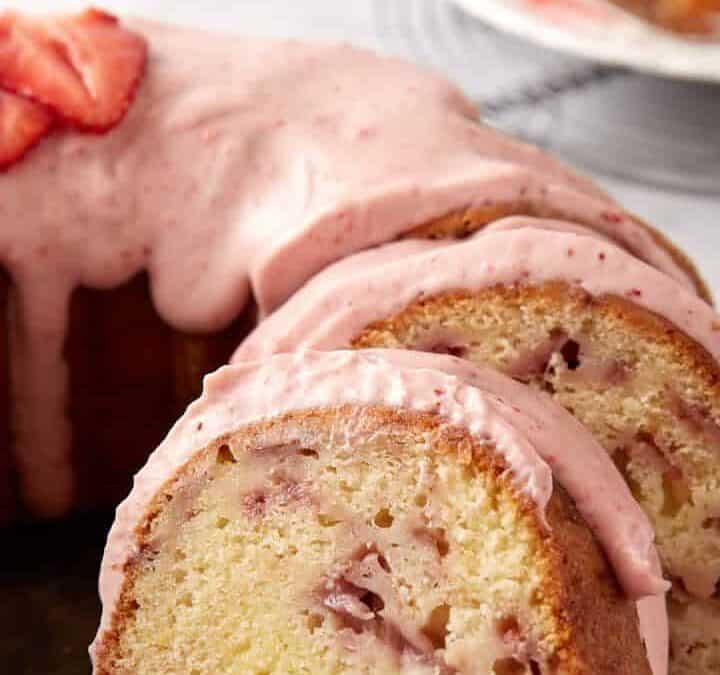 A strawberry bundt cake on a platter, sliced.