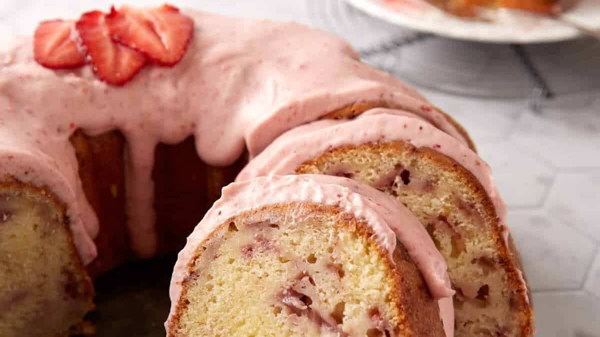 A strawberry bundt cake on a platter, sliced.