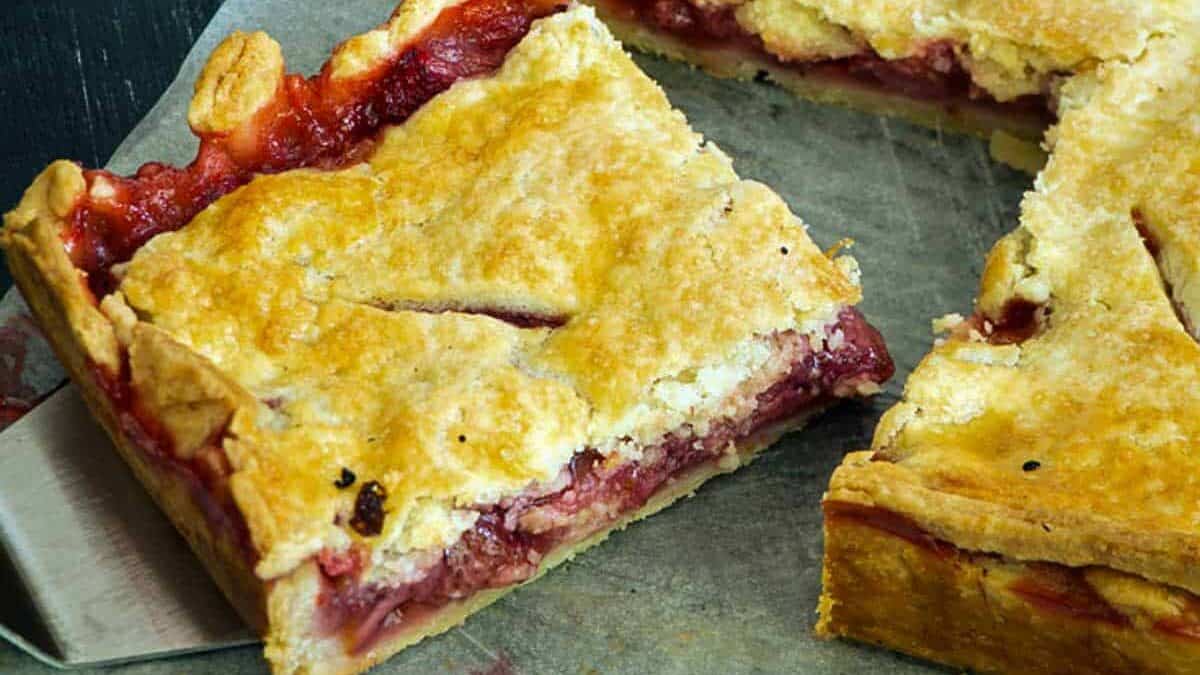 A serving being removed from a strawberry pie