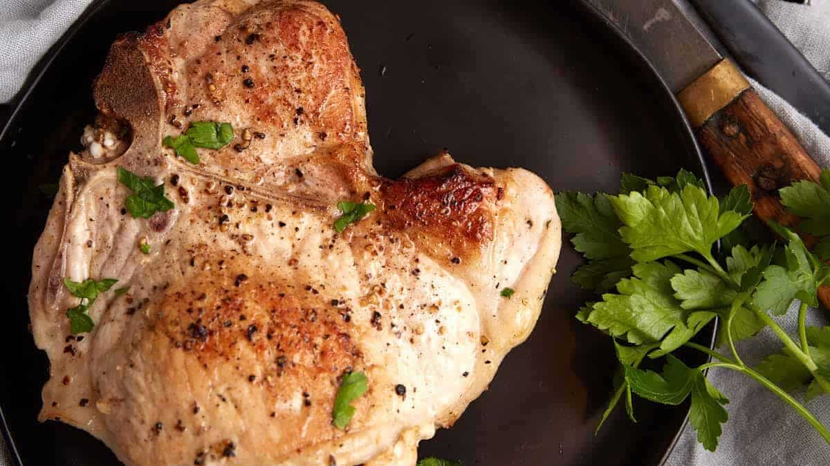 A single pork chop with stuffing on a plate.