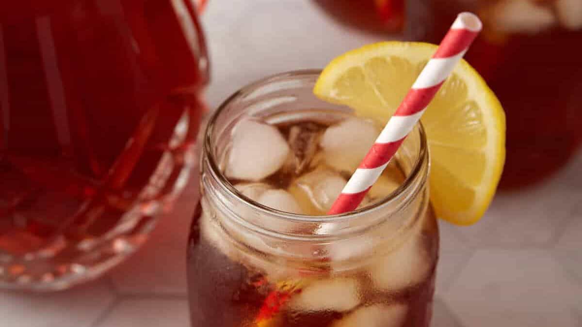 A pitcher with glasses of sweet iced tea.