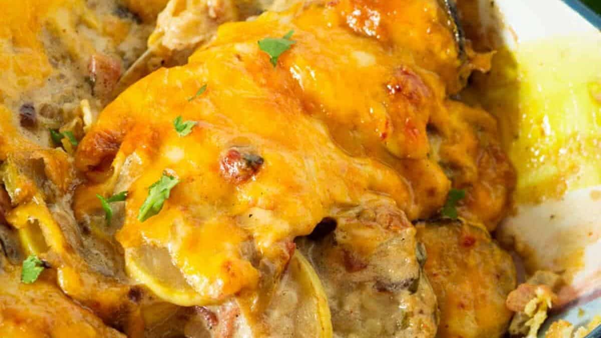 A baking dish with squash casserole covered in cheese.