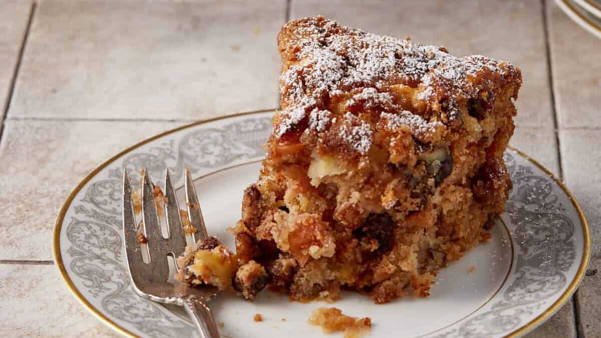 A slice of apple spice cake with a bite taken out.